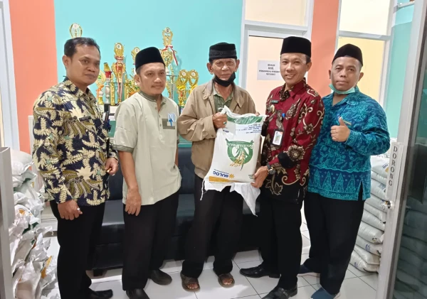 Lurah Kepuh Ciwandan H.Holilullah Berbaur dengan Warga dalam Pembagian Beras PKH.
